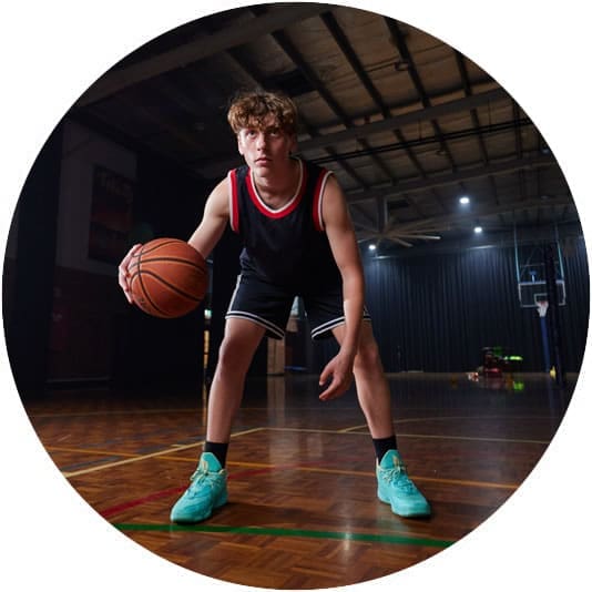 Young person facing the camera playing basketball