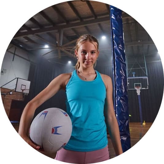 Young person holding a netball facing the camera