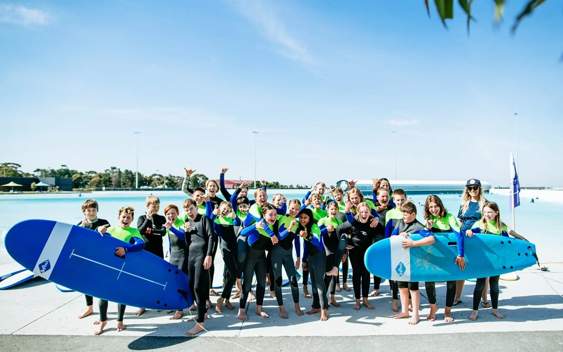 Group of children smiling and holding surfboards